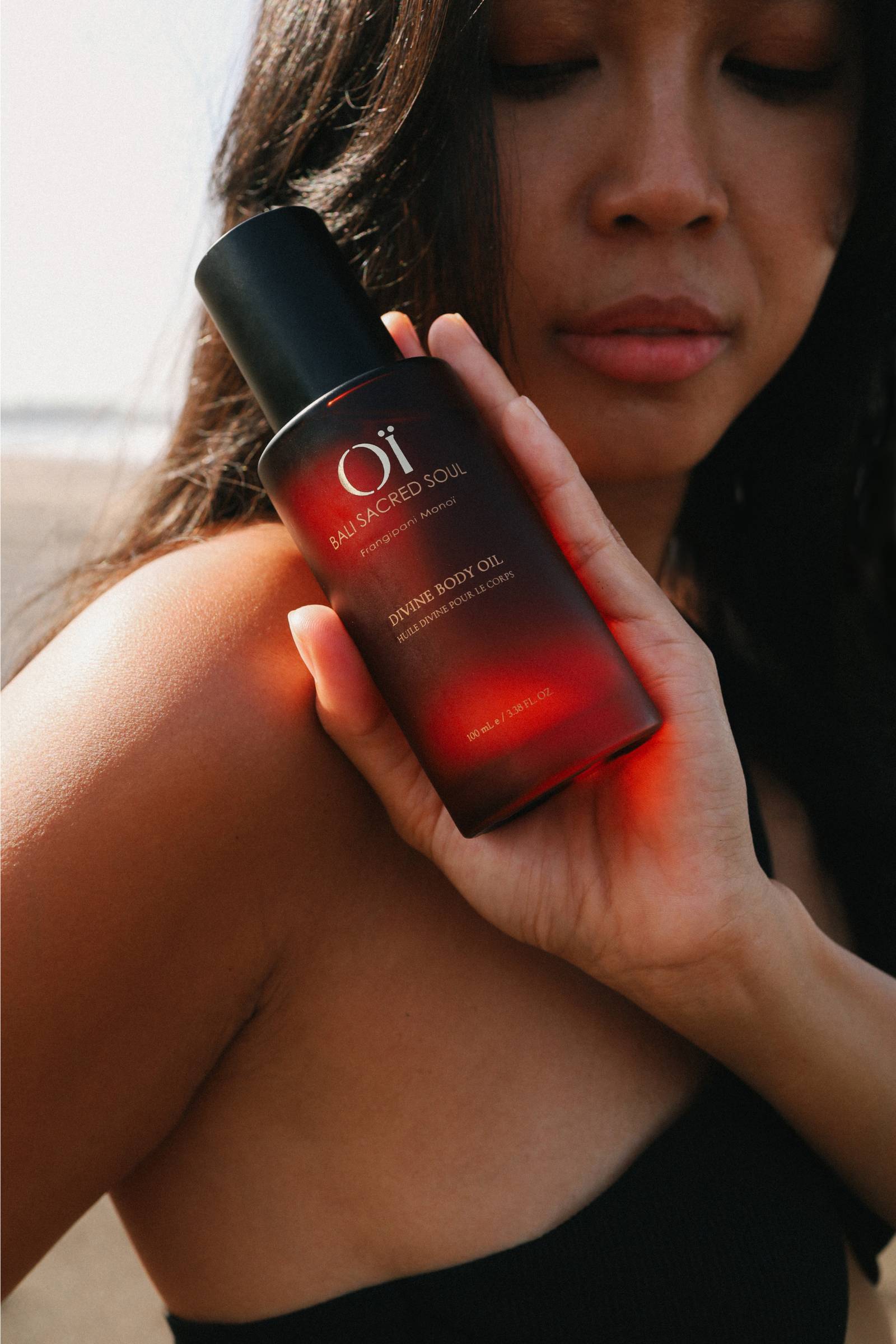 Femme tenant dans sa main la Divine Body oil